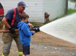 Firefighter Bellerose & student spraying water
