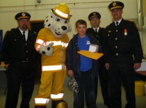 Winner of the Blue Jays Tickets with Deputy Chief Stn 2 Scott Richards, Sparky, Deputy Chief Stn 1 Dave Smith, & Fire Chief Gib Medve